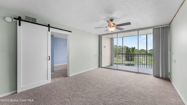 1420 Huntington Ln Unit 2405, Rockledge, FL 32955 - carpeted spare room with a wall of windows, a barn door, a ceiling fan, a textured ceiling, and a smoke detector