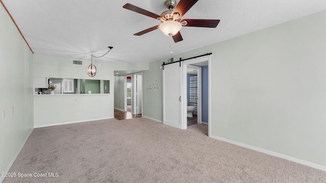 1420 Huntington Ln Unit 2405, Rockledge, FL 32955 - unfurnished living room with a barn door, carpet flooring, a ceiling fan, and a chandelier