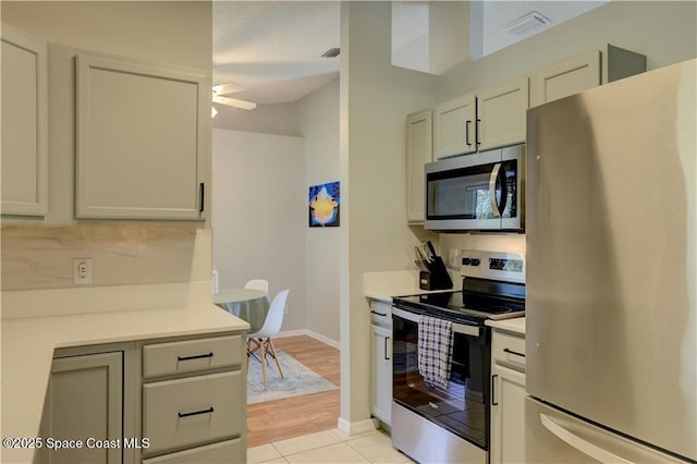 241 High Rd NW, Palm Bay, FL 32907 - kitchen featuring appliances with stainless steel finishes, light countertops, light tile patterned floors, and baseboards