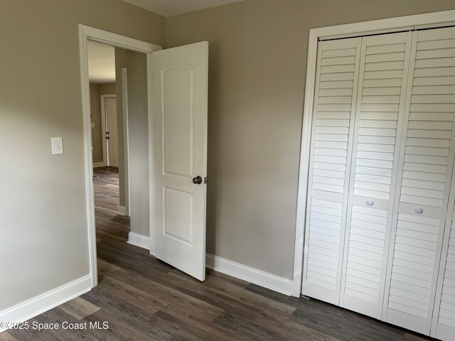 711 Sara Jane Ln, Merritt Island, FL 32952 - unfurnished bedroom with dark wood-style flooring, baseboards, and a closet