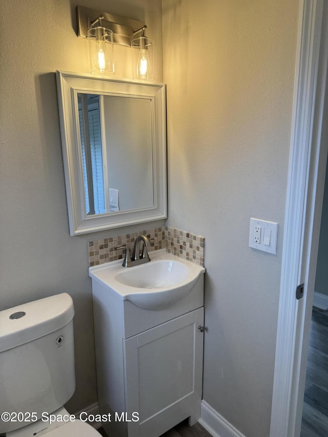 711 Sara Jane Ln, Merritt Island, FL 32952 - half bathroom with vanity, tasteful backsplash, and toilet