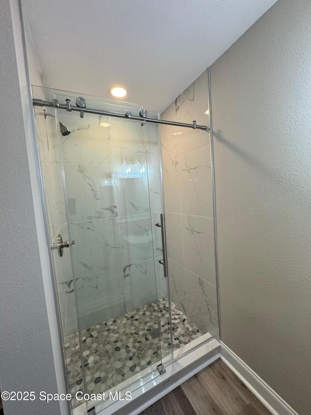 711 Sara Jane Ln, Merritt Island, FL 32952 - full bathroom featuring wood finished floors, a marble finish shower, and baseboards