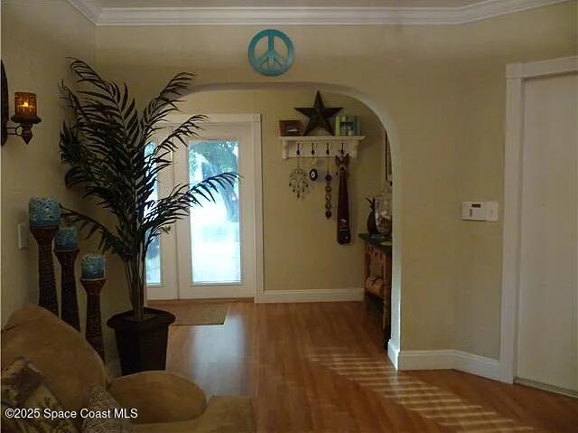 22100 Serenata Cir W, Boca Raton, FL 33428 - foyer entrance featuring arched walkways, baseboards, wood finished floors, and ornamental molding