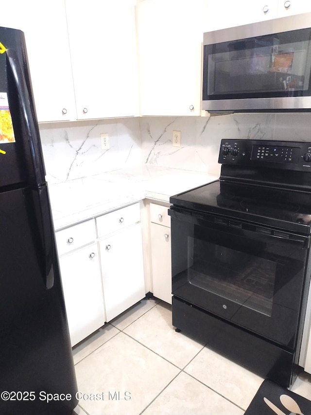 1470 Sheafe Ave NE Unit 108, Palm Bay, FL 32905 - kitchen with black appliances, white cabinets, light countertops, light tile patterned floors, and backsplash