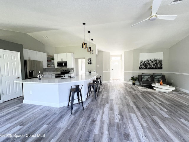 1271 Rabbit St SE, Palm Bay, FL 32909 - kitchen with stainless steel appliances, vaulted ceiling, light wood-style flooring, light countertops, and a ceiling fan