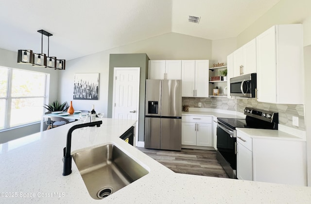 1271 Rabbit St SE, Palm Bay, FL 32909 - kitchen featuring stainless steel appliances, a sink, open shelves, vaulted ceiling, and backsplash