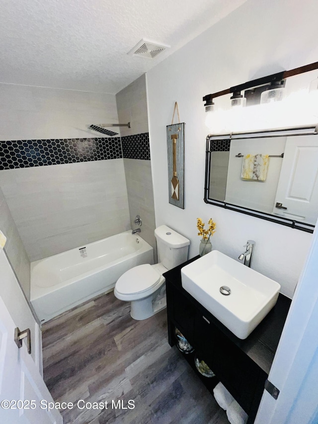 1271 Rabbit St SE, Palm Bay, FL 32909 - bathroom featuring tub / shower combination, wood finished floors, toilet, vanity, and a textured ceiling