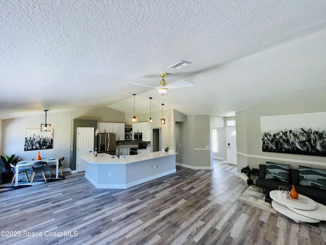 1271 Rabbit St SE, Palm Bay, FL 32909 - living area with vaulted ceiling, dark wood-style flooring, a textured ceiling, ceiling fan, and baseboards