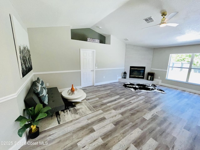 1271 Rabbit St SE, Palm Bay, FL 32909 - living area with wood finished floors, vaulted ceiling, ceiling fan, baseboards, and a fireplace