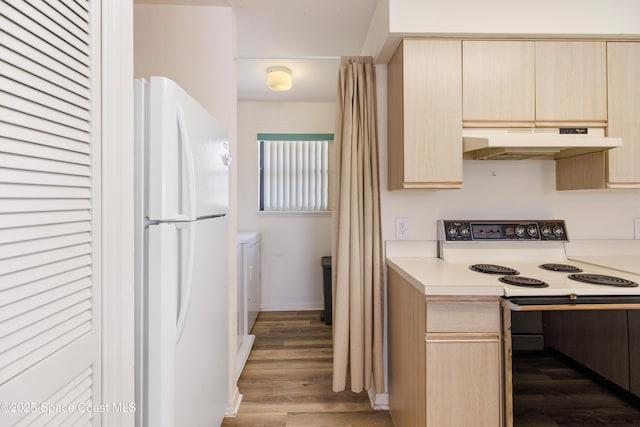 654 Centre Ct SW Unit 201, Vero Beach, FL 32962 - kitchen featuring under cabinet range hood, freestanding refrigerator, light brown cabinets, and washer and dryer