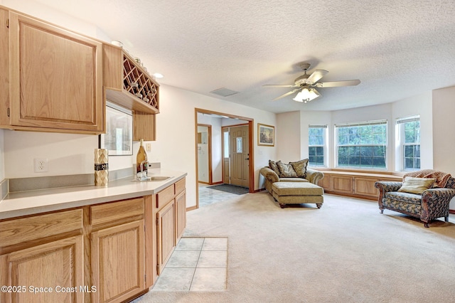 2575 Cox Rd, Cocoa, FL 32926 - kitchen featuring light colored carpet, open floor plan, light countertops, a ceiling fan, and light brown cabinetry