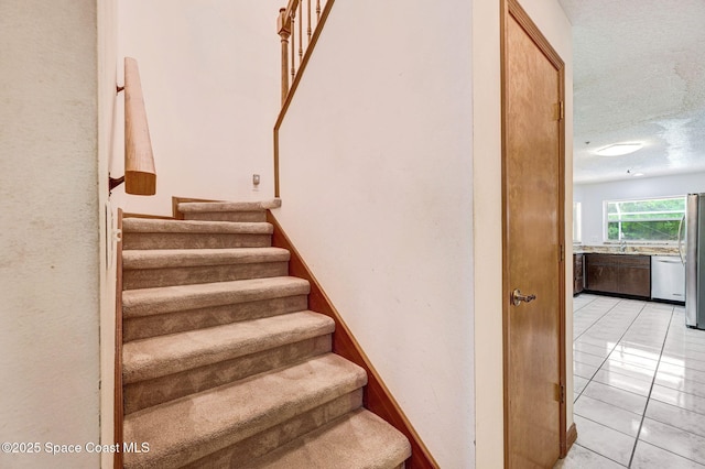 2575 Cox Rd, Cocoa, FL 32926 - staircase with tile patterned flooring and a textured ceiling