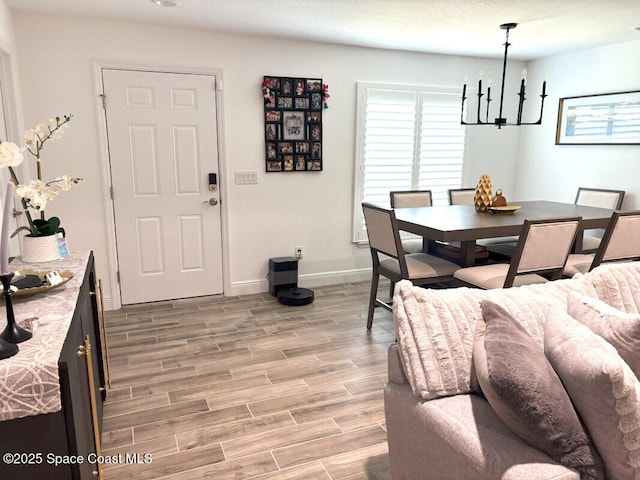 259 Wilton Ave SW, Palm Bay, FL 32908 - dining area featuring a chandelier, plenty of natural light, light wood-style flooring, and baseboards