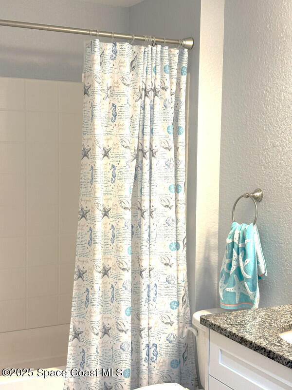 259 Wilton Ave SW, Palm Bay, FL 32908 - bathroom with a textured wall, vanity, a shower with shower curtain, and toilet