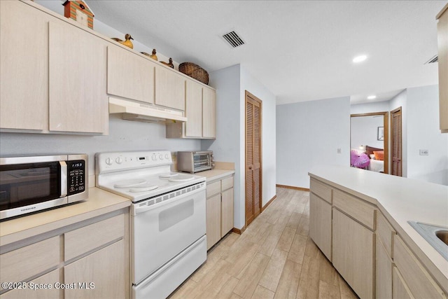 5997 Jenkins Ave, Cocoa, FL 32927 - kitchen with white electric stove, stainless steel microwave, under cabinet range hood, light countertops, and light wood-type flooring