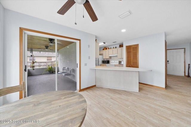 5997 Jenkins Ave, Cocoa, FL 32927 - kitchen with a ceiling fan, white electric stove, freestanding refrigerator, light countertops, and a peninsula
