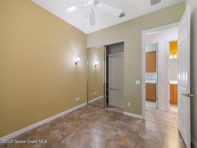 5422 Barbados Sq, Vero Beach, FL 32967 - unfurnished bedroom featuring a closet, baseboards, ceiling fan, and light stone finish floors