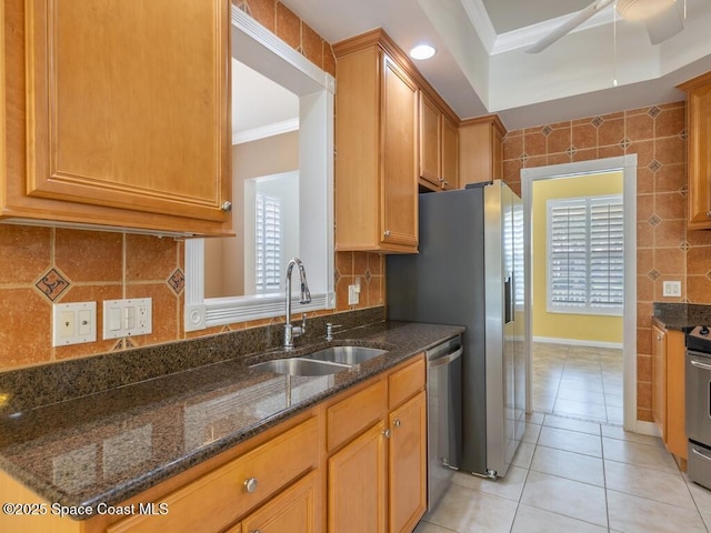 5422 Barbados Sq, Vero Beach, FL 32967 - kitchen with a sink, appliances with stainless steel finishes, crown molding, light tile patterned flooring, and dark stone counters