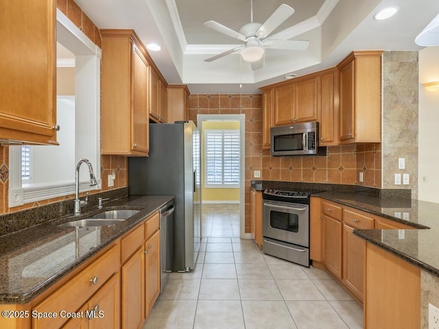 5422 Barbados Sq, Vero Beach, FL 32967 - kitchen featuring stainless steel appliances, a sink, a raised ceiling, a ceiling fan, and dark stone countertops