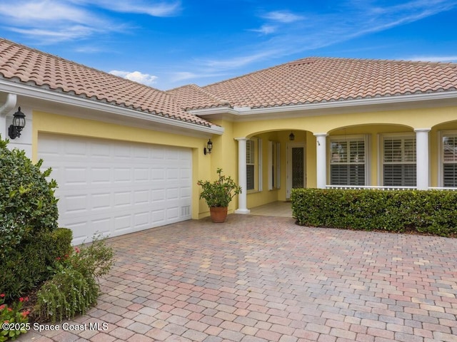 5422 Barbados Sq, Vero Beach, FL 32967 - view of front of home featuring stucco siding, decorative driveway, a tile roof, and a garage