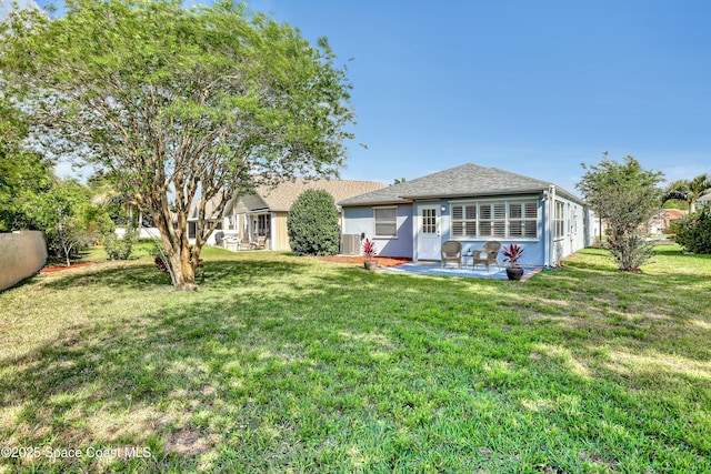 1020 S Fork Cir, Melbourne, FL 32901 - rear view of house featuring a patio, a lawn, and a shingled roof