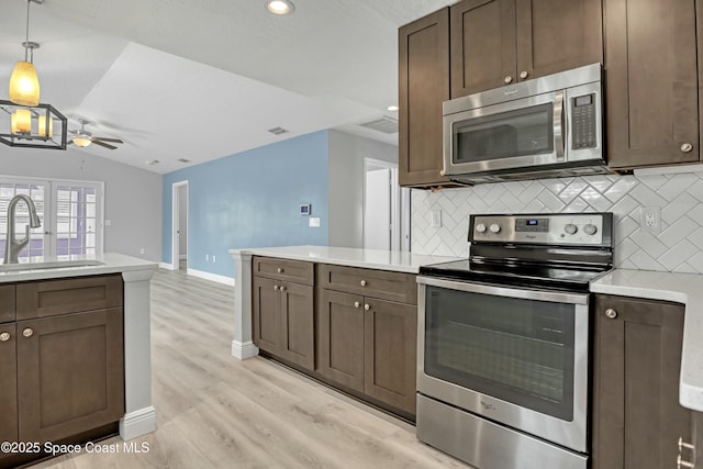 1020 S Fork Cir, Melbourne, FL 32901 - kitchen featuring stainless steel appliances, decorative backsplash, ceiling fan, light countertops, and recessed lighting