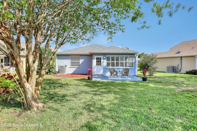 1020 S Fork Cir, Melbourne, FL 32901 - rear view of house with stucco siding, a patio, a lawn, and roof with shingles