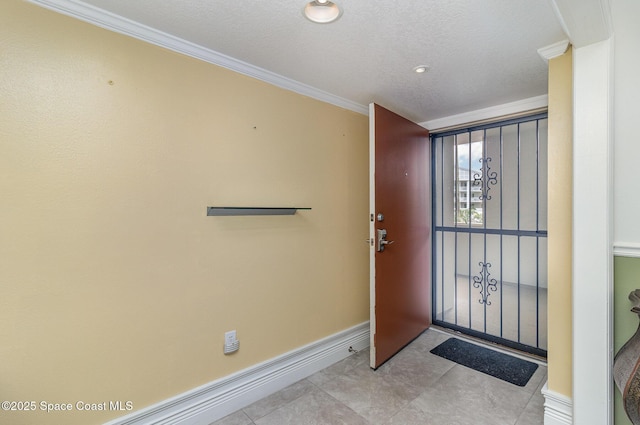 2260 Front St Unit 103, Melbourne, FL 32901 - entryway featuring ornamental molding, baseboards, a textured ceiling, and light tile patterned floors