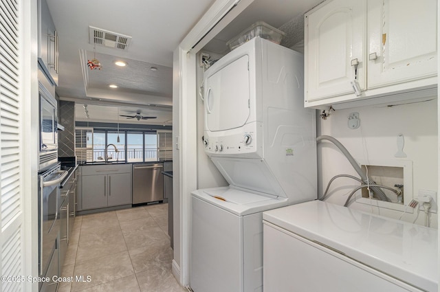 2260 Front St Unit 103, Melbourne, FL 32901 - laundry area featuring stacked washer / dryer, recessed lighting, ceiling fan, and light tile patterned flooring