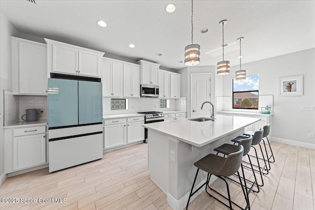 7917 Dobre Way, Melbourne, FL 32940 - kitchen featuring appliances with stainless steel finishes, white cabinetry, recessed lighting, light wood-style flooring, and decorative backsplash