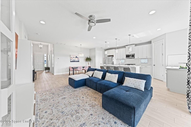 7917 Dobre Way, Melbourne, FL 32940 - living room featuring a ceiling fan, light wood-style flooring, recessed lighting, and baseboards
