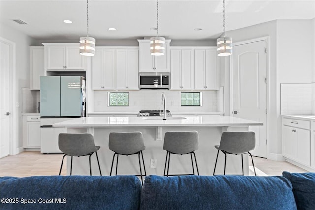 7917 Dobre Way, Melbourne, FL 32940 - kitchen with freestanding refrigerator, stainless steel microwave, a sink, light countertops, and recessed lighting