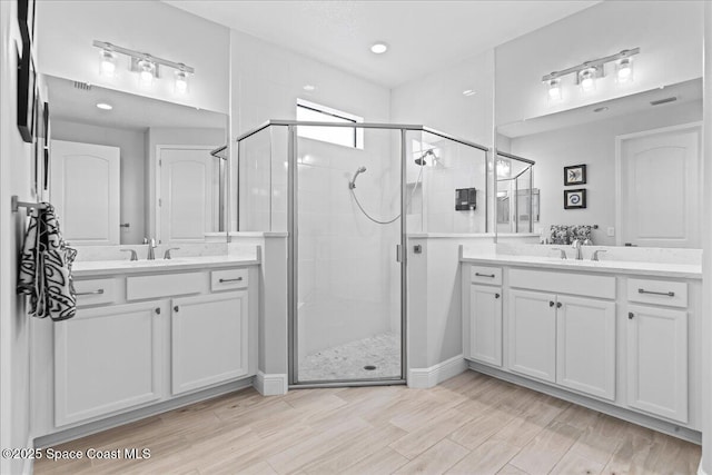 7917 Dobre Way, Melbourne, FL 32940 - full bath with a shower stall, two vanities, and wood finished floors