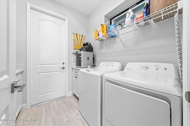 7917 Dobre Way, Melbourne, FL 32940 - laundry area featuring independent washer and dryer, cabinet space, wood tiled floors, and baseboards