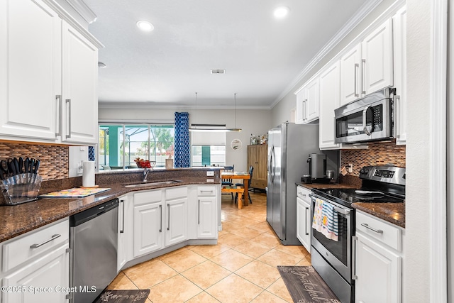 125 Rudy St, Auburndale, FL 33823 - kitchen with stainless steel appliances, white cabinetry, light tile patterned flooring, crown molding, and backsplash
