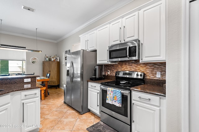 125 Rudy St, Auburndale, FL 33823 - kitchen with appliances with stainless steel finishes, ornamental molding, white cabinets, light tile patterned flooring, and tasteful backsplash