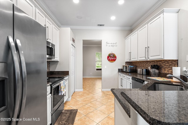 125 Rudy St, Auburndale, FL 33823 - kitchen featuring stainless steel appliances, white cabinetry, light tile patterned flooring, ornamental molding, and backsplash
