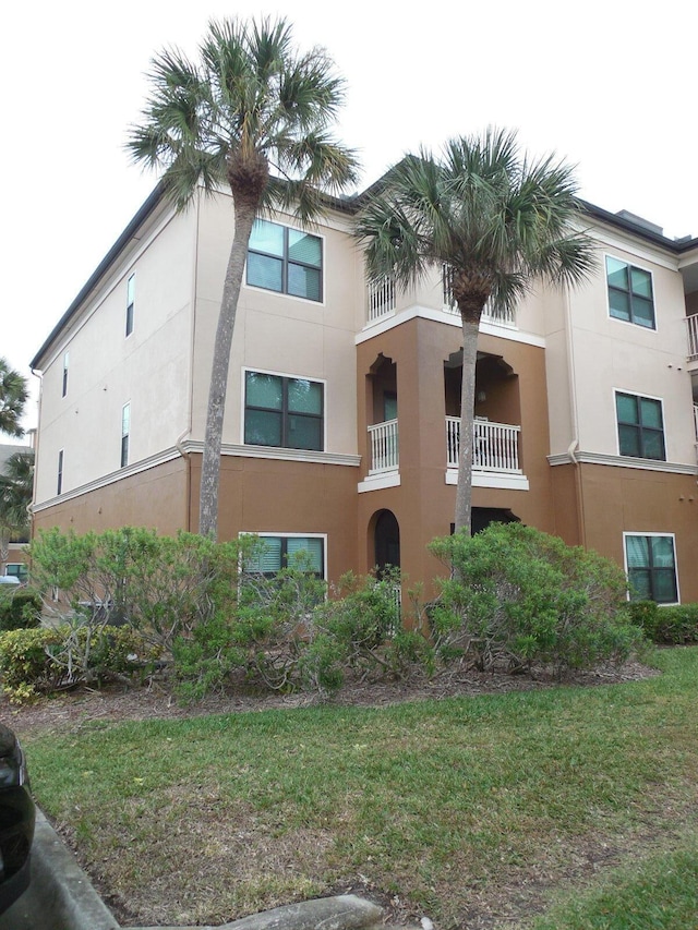 6460 Borasco Dr Unit 2903, Melbourne, FL 32940 - view of side of home featuring stucco siding and a lawn