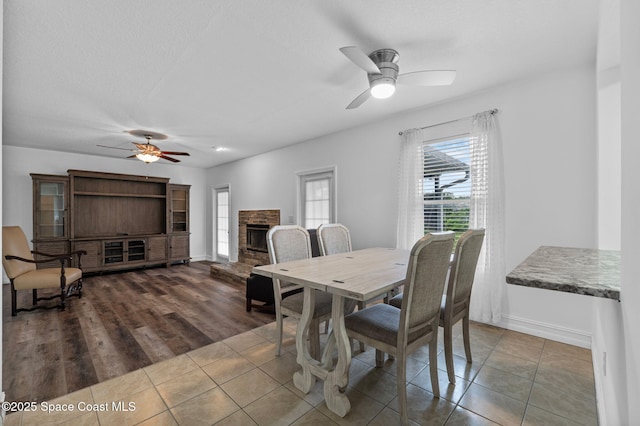 3435 Felda St, Cocoa, FL 32926 - dining room featuring a ceiling fan, a fireplace, baseboards, and tile patterned flooring
