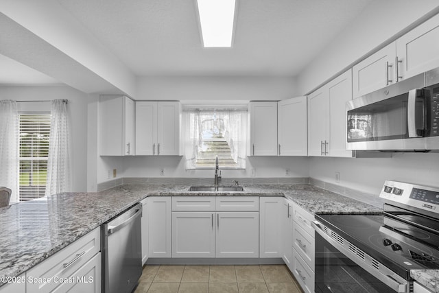 3435 Felda St, Cocoa, FL 32926 - kitchen featuring stainless steel appliances, a sink, white cabinetry, light tile patterned floors, and light stone countertops