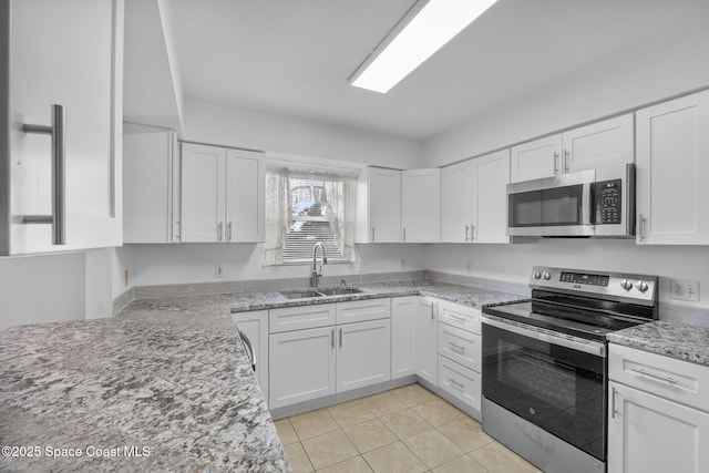 3435 Felda St, Cocoa, FL 32926 - kitchen featuring stainless steel appliances, a sink, white cabinetry, light stone counters, and light tile patterned flooring