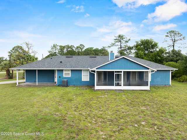 3435 Felda St, Cocoa, FL 32926 - back of property with a sunroom, a chimney, central air condition unit, a yard, and a shingled roof