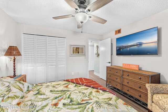 200 International Dr Unit 817, Cape Canaveral, FL 32920 - bedroom with a closet, a textured ceiling, wood finished floors, and ceiling fan