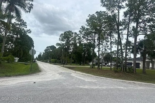 12144 66th St N, West Palm Beach, FL 33415 - view of asphalt road featuring traffic signs