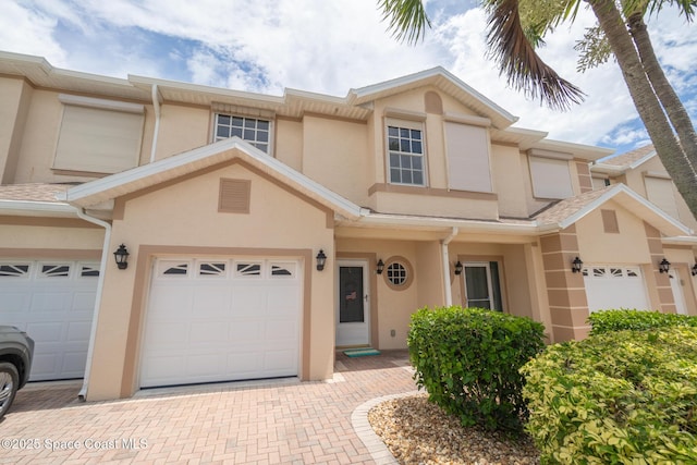 5201 Ocean Beach Blvd Unit 4, Cocoa Beach, FL 32931 - view of property with stucco siding, decorative driveway, and a garage