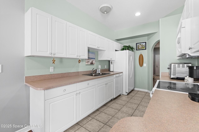 5201 Ocean Beach Blvd Unit 4, Cocoa Beach, FL 32931 - kitchen with white appliances, arched walkways, white cabinets, light tile patterned floors, and light countertops