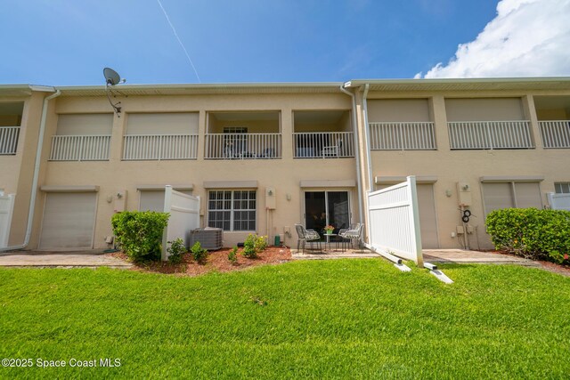 5201 Ocean Beach Blvd Unit 4, Cocoa Beach, FL 32931 - rear view of house with stucco siding, a lawn, and a balcony