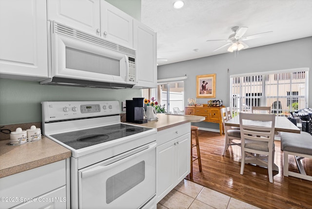 5201 Ocean Beach Blvd Unit 4, Cocoa Beach, FL 32931 - kitchen with white appliances, ceiling fan, white cabinetry, light countertops, and recessed lighting