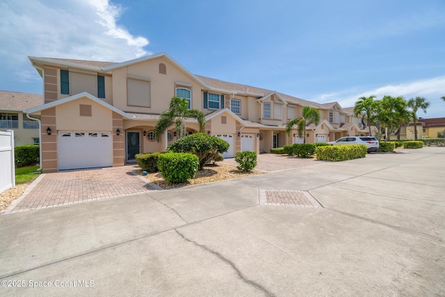 5201 Ocean Beach Blvd Unit 4, Cocoa Beach, FL 32931 - multi unit property with decorative driveway, stucco siding, a residential view, and a garage