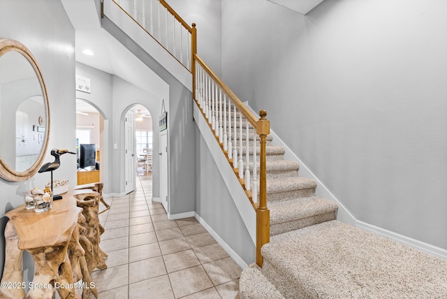 5201 Ocean Beach Blvd Unit 4, Cocoa Beach, FL 32931 - foyer entrance featuring light tile patterned flooring, stairway, arched walkways, and a high ceiling